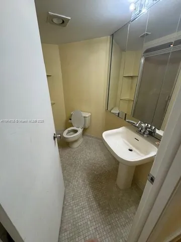 a bathroom with a sink a toilet and a mirror