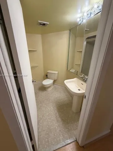a bathroom with a sink a toilet a mirror and vanity