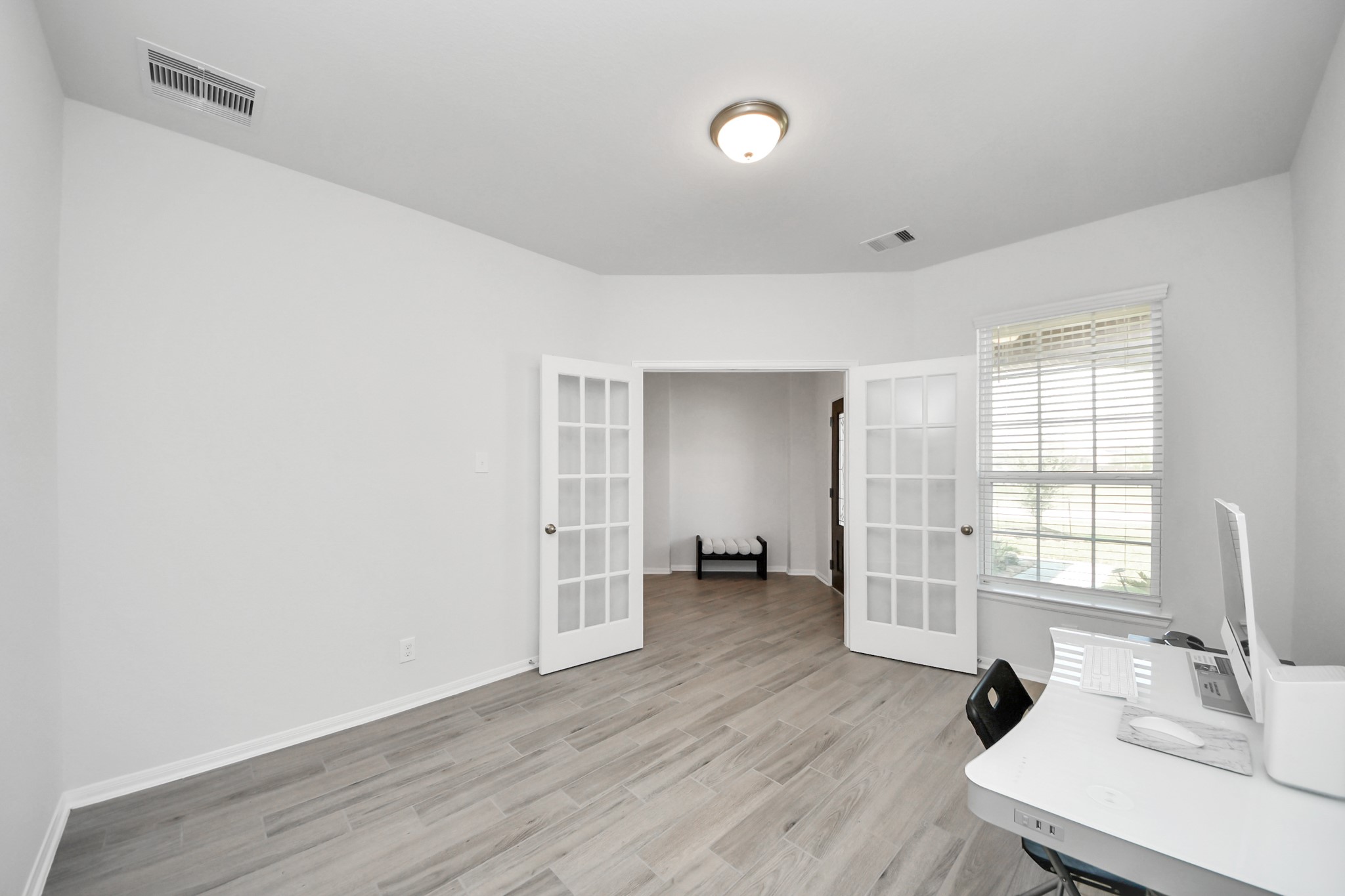 10603 Juniper Br Drive Rosharon, TX 77583 - Photo 8 of 50 Bright and spacious room with light wood flooring, featuring French doors and a large window for natural light. Ideal for a home office or study area.