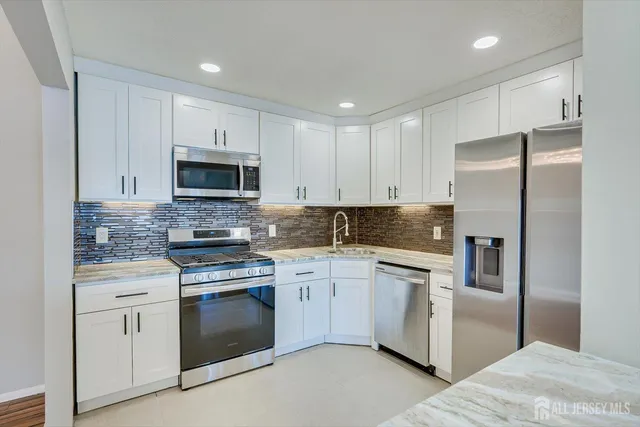 a kitchen with cabinets stainless steel appliances and sink