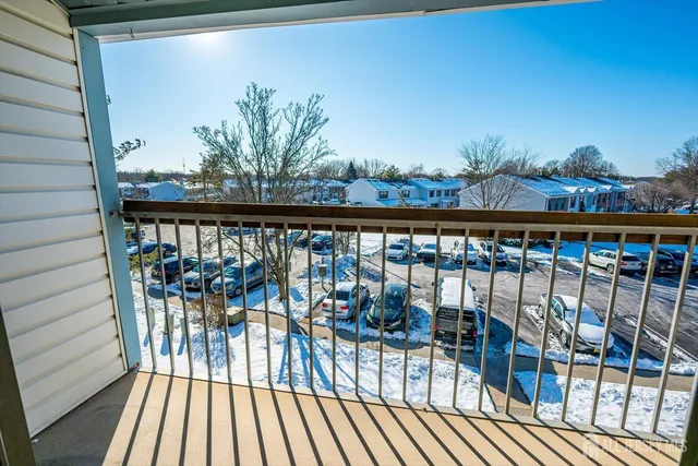 a view of a balcony with chairs and wooden floor