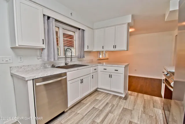 a kitchen with a sink window and cabinets