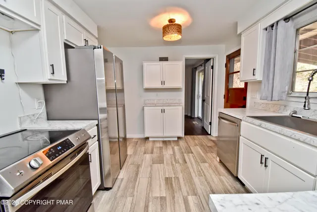 a kitchen with stainless steel appliances a stove a sink and a refrigerator