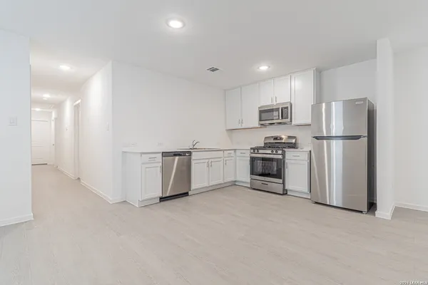 a kitchen with stainless steel appliances a refrigerator and a stove top oven