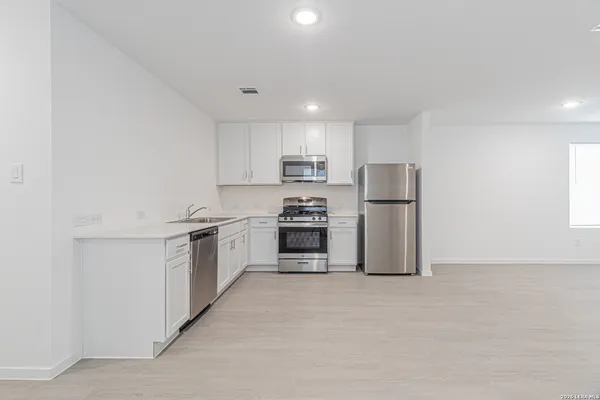 a kitchen with refrigerator a microwave and stove