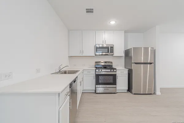 a kitchen with stainless steel appliances a refrigerator sink and stove