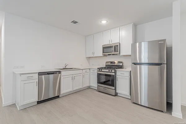 a kitchen with refrigerator a stove top oven a sink and dishwasher
