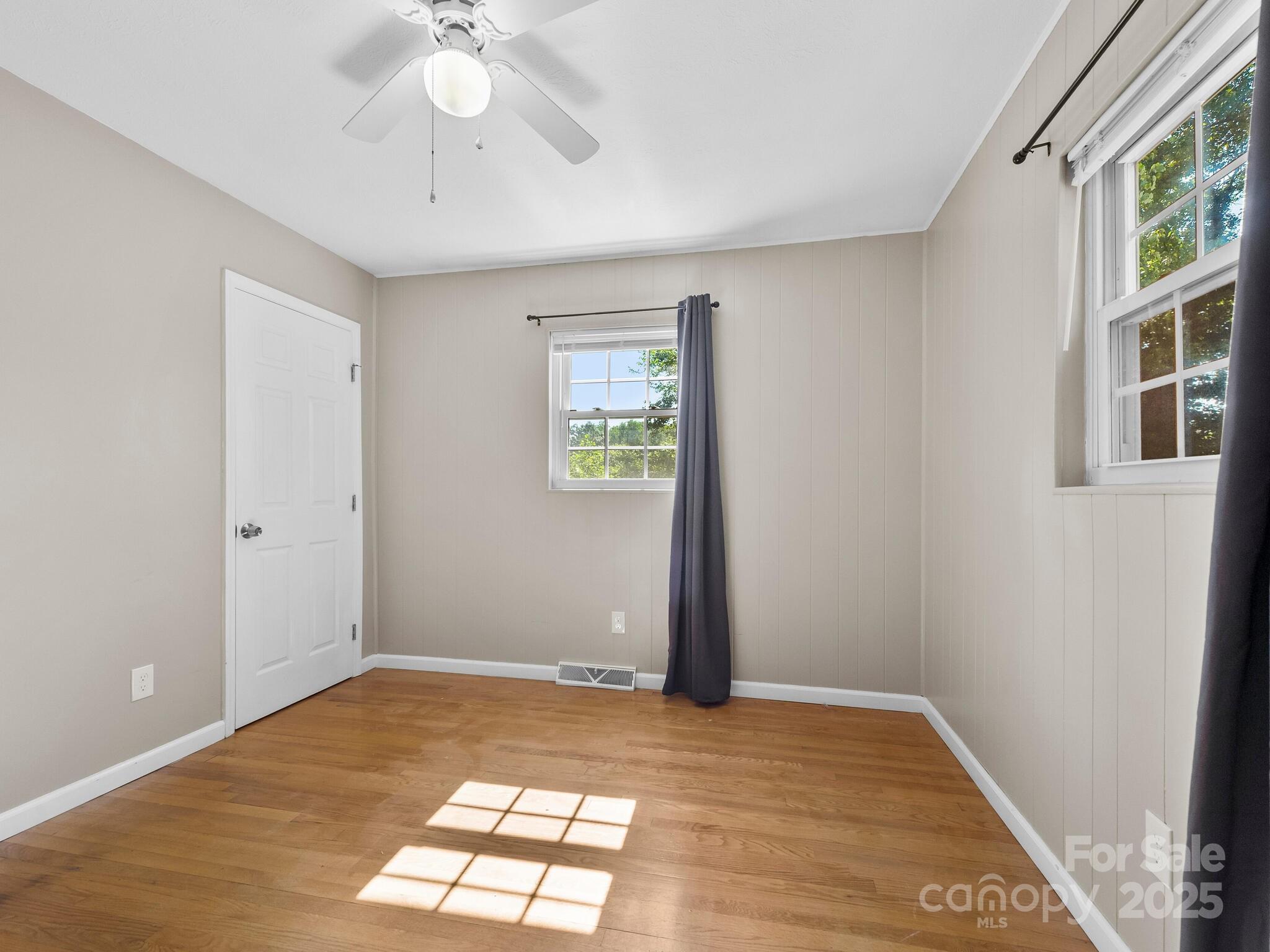 8 Vista Knoll Road Candler, NC 28715 - Photo 17 of 32 a view of an empty room with window and wooden floor