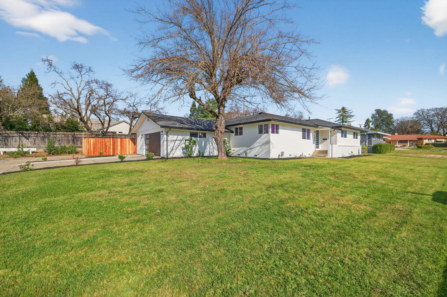 a view of a house with a big yard and sitting area