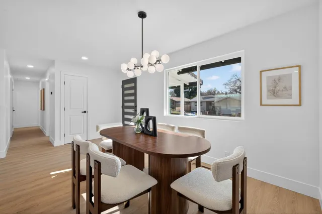a view of a dining room with furniture wooden floor and a chandelier