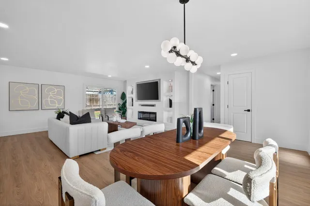 a living room with furniture a chandelier and a flat screen tv
