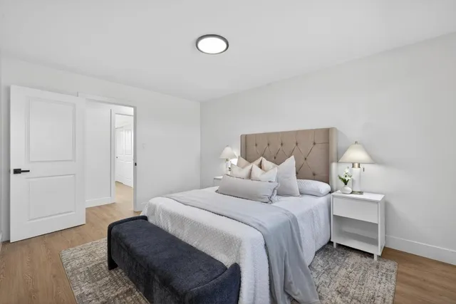 a bedroom with a bed and wooden floor