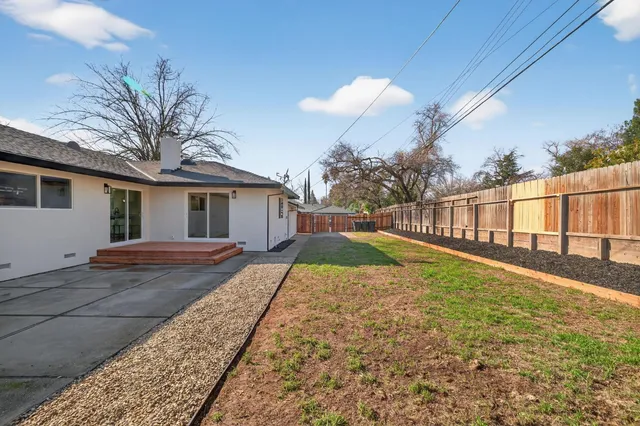 a view of house with backyard and tree