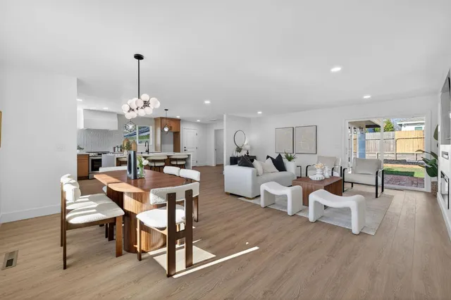 a living room with furniture a chandelier and a table