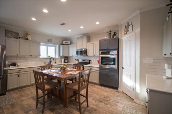 a kitchen with a table chairs sink and cabinets