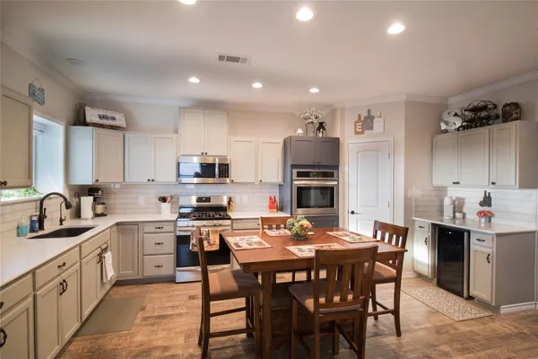 a kitchen with a dining table chairs and refrigerator
