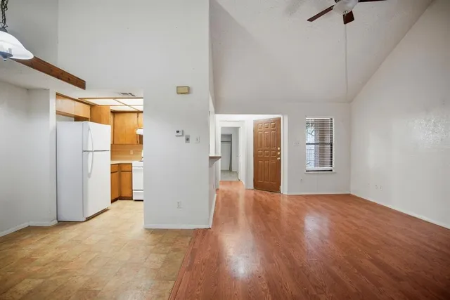 a view of a big room with wooden floor and windows