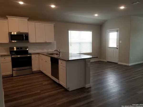 a kitchen with a sink and wooden floor
