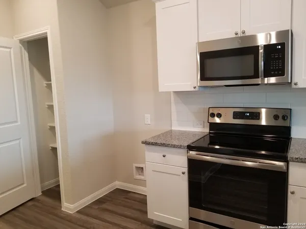 a view of a kitchen with wooden floor and a window