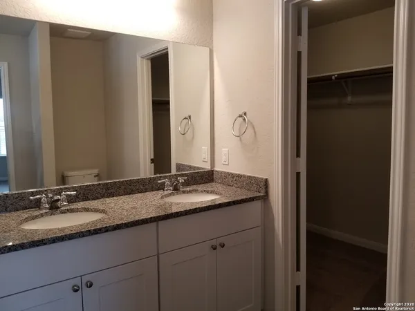 a bathroom with a granite countertop shower and a sink