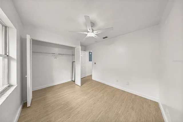 an empty room with a white cabinet and a ceiling fan
