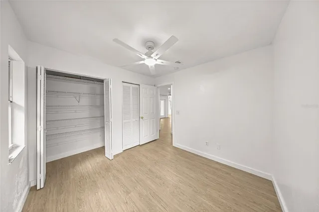 an empty room with closet and windows