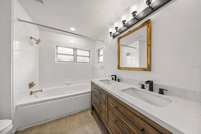 a bathroom with a double vanity sink mirror double and bathtub