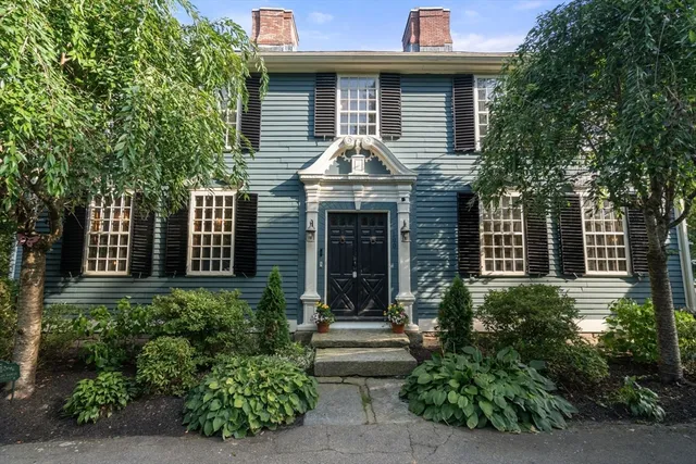 a front view of a house with plants