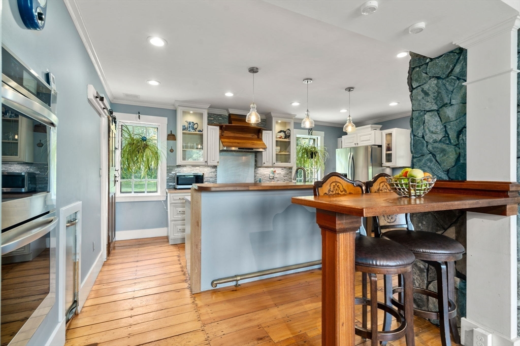 100 Eliot Street Natick, MA 01760 - Photo 8 of 41 a kitchen with stainless steel appliances kitchen island granite countertop a table chairs sink and cabinets