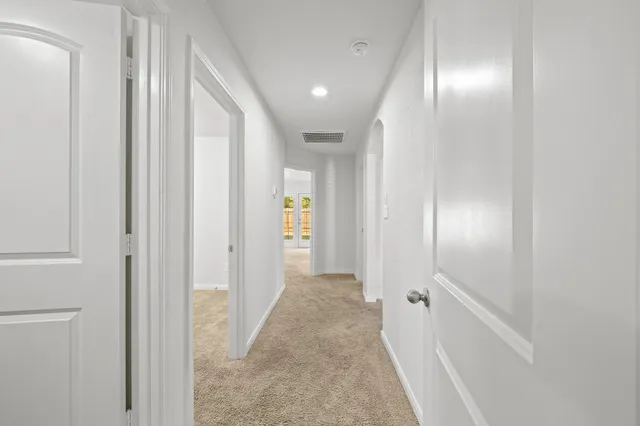 a view of a hallway with wooden shelves