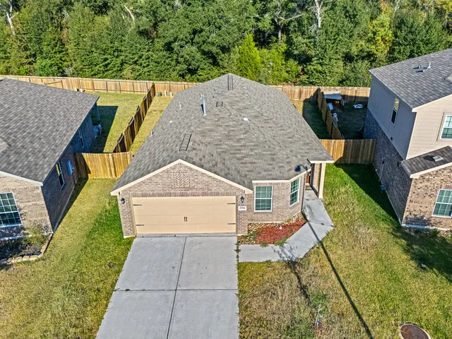 an aerial view of a house with swimming pool and large trees