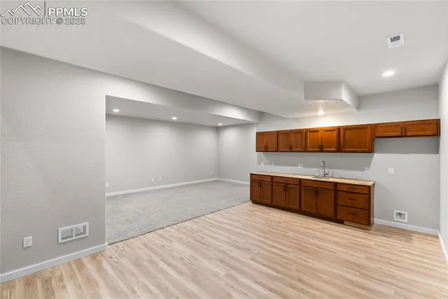 a large kitchen with stainless steel appliances a large counter top and a wooden floors