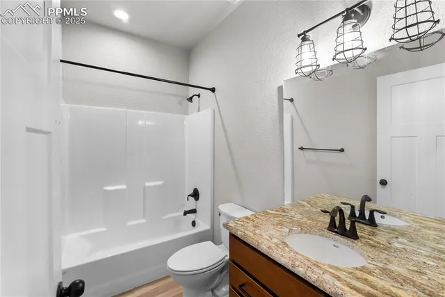 a bathroom with a granite countertop sink toilet a shower and a mirror