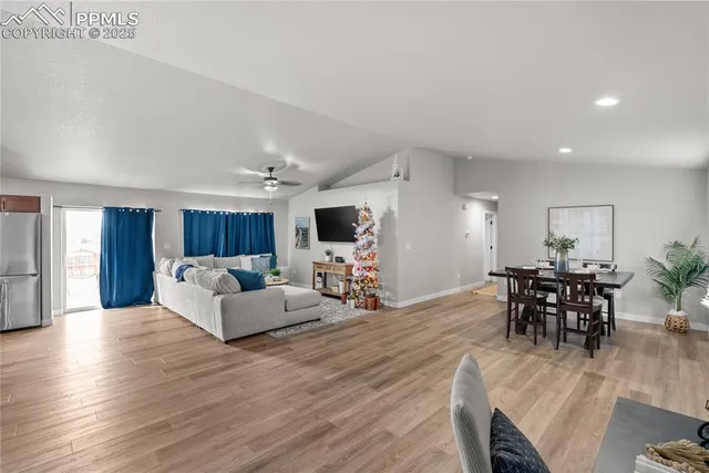 a living room with furniture a wooden floor and a dining table