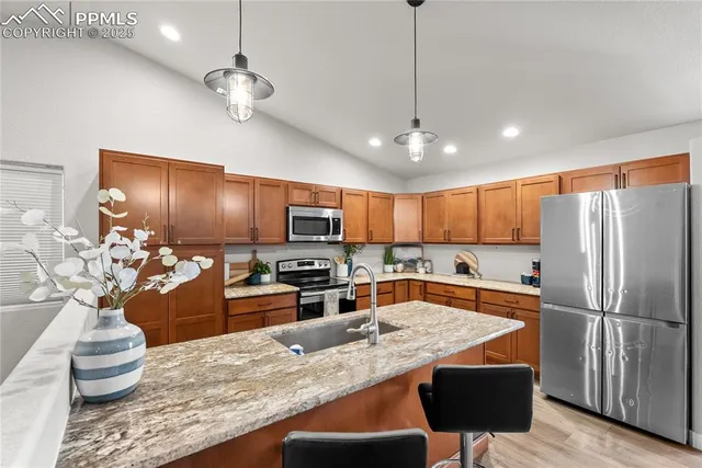 a kitchen with stainless steel appliances granite countertop a sink refrigerator stove and microwave