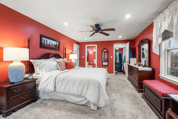 a spacious bedroom with a bed and wooden floors