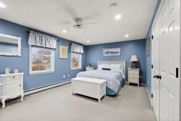 a spacious bedroom with a bed and a dresser