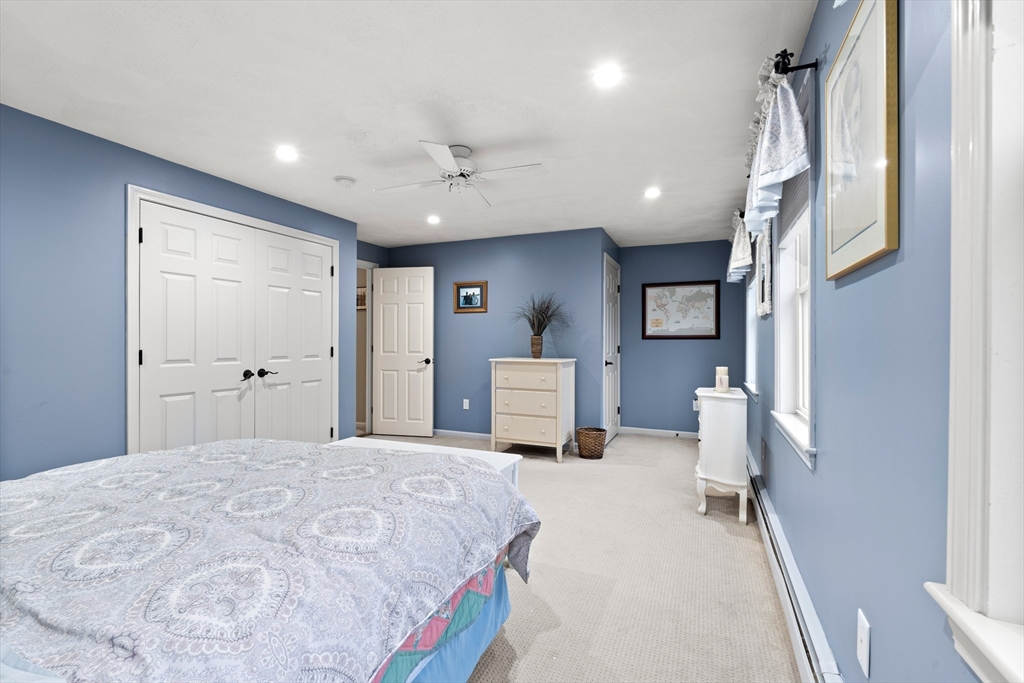 27 Folger Avenue Beverly, MA 01915 - Photo 23 of 34 a spacious bedroom with a bed and a chandelier