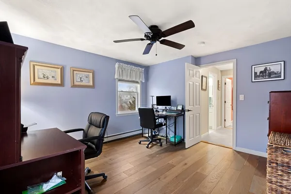 a view of a workspace with furniture and a window