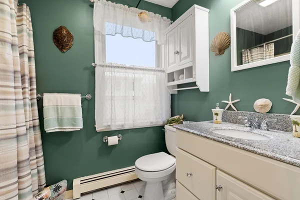 a bathroom with a granite countertop toilet sink and mirror