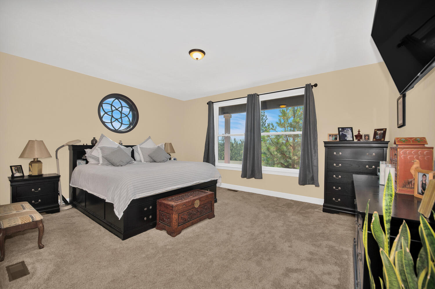 19112 Pumice Butte Road Bend, OR 97702 - Photo 19 of 36 a spacious bedroom with a bed and a flat tv screen on dresser
