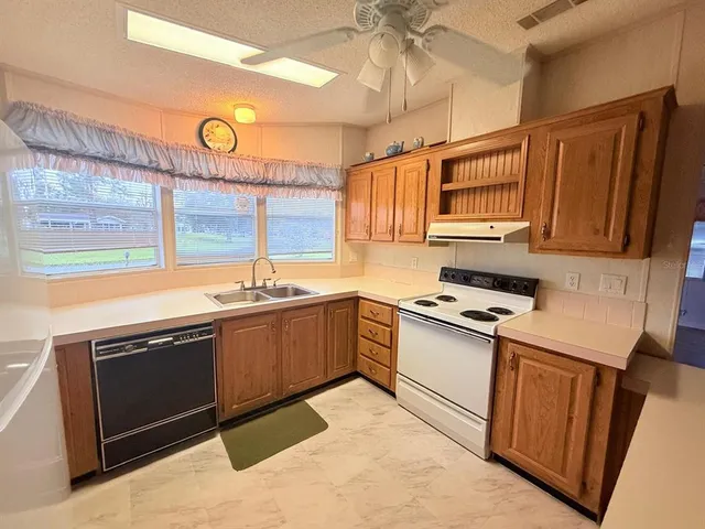 a kitchen with stainless steel appliances granite countertop a sink and a stove