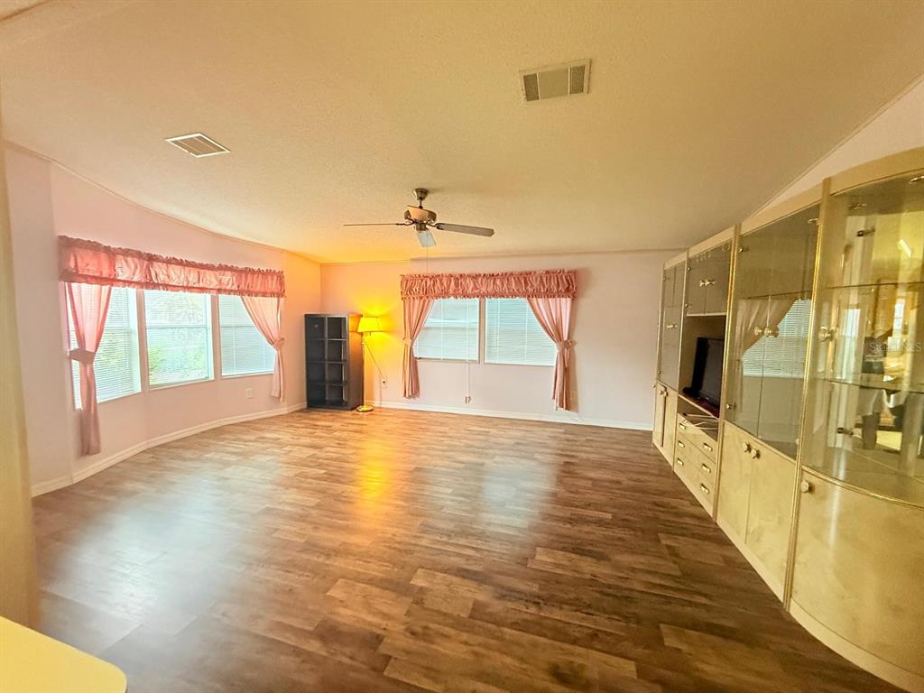 220 Ellsworth Drive Kissimmee, FL 34758 - Photo 14 of 40 a view of an empty room with wooden floor and a window