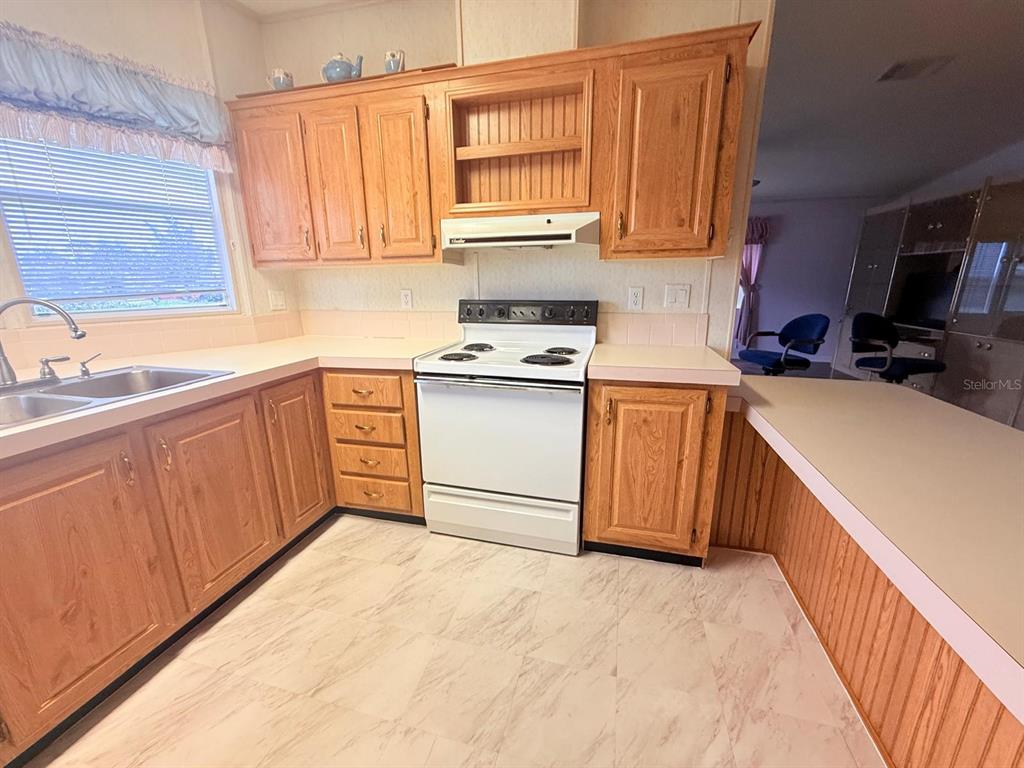 220 Ellsworth Drive Kissimmee, FL 34758 - Photo 15 of 40 a kitchen with stainless steel appliances granite countertop a sink stove and cabinets