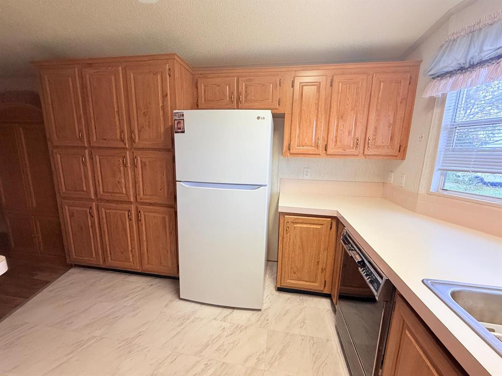 220 Ellsworth Drive Kissimmee, FL 34758 - Photo 16 of 40 a kitchen with a refrigerator a stove top oven and a refrigerator