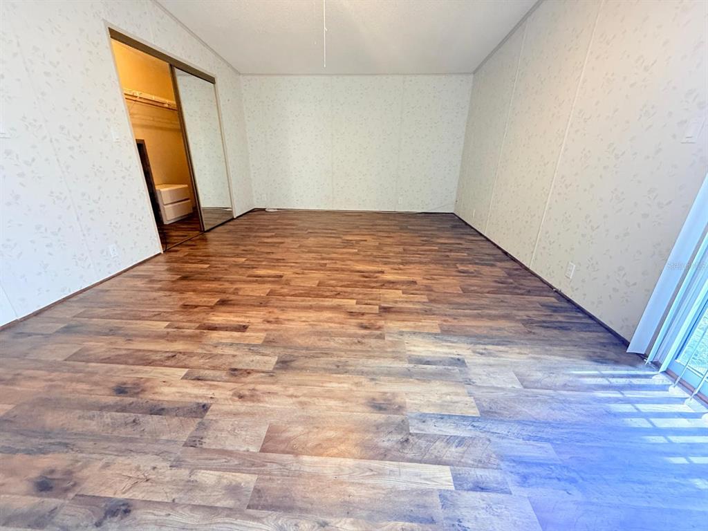 220 Ellsworth Drive Kissimmee, FL 34758 - Photo 20 of 40 a view of empty room with wooden floor and fan