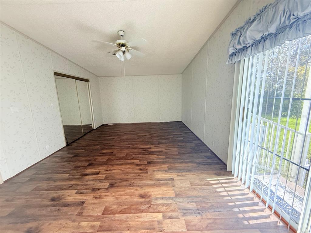 220 Ellsworth Drive Kissimmee, FL 34758 - Photo 23 of 40 an empty room with wooden floor fan and windows