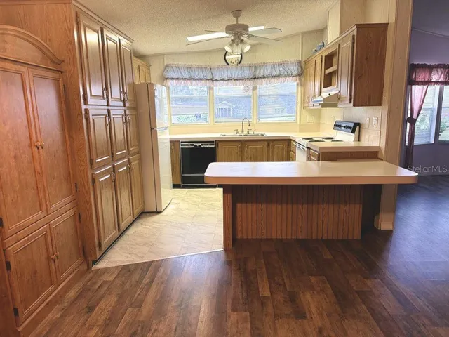 a large kitchen with wooden floor and a sink