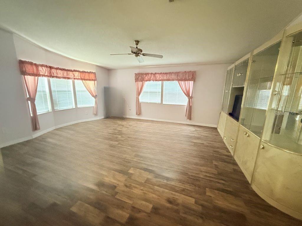 220 Ellsworth Drive Kissimmee, FL 34758 - Photo 10 of 40 a view of an empty room with wooden floor and a window