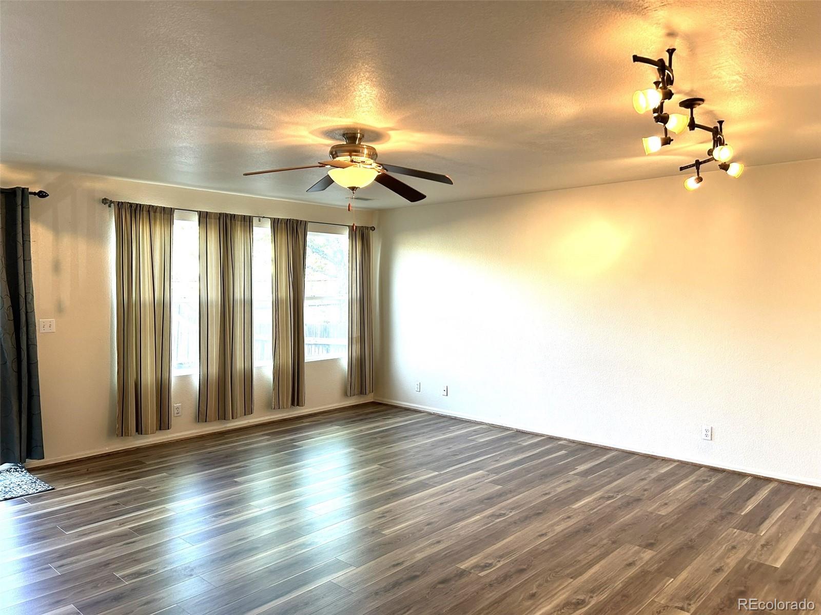9325 Welby Rd Terrace Denver, CO 80229 - Photo 4 of 21 wooden floor in an empty room with a window